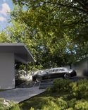 A modern villa with a Rolls-Royce surrounded by green trees by Studia 54