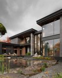 A combination of light wood, grey stone, panoramic glazing and warm outdoor landscape lighting